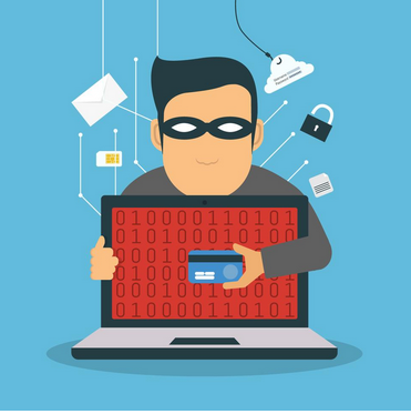 masked man holding stolen credit card in front of computer screen